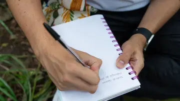 Persona escribiendo en cuaderno