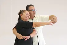Señor y señora agarrados de la mano, aparentemente bailando