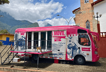 Biblioteca móvil de Comfama en el parque de un pueblo