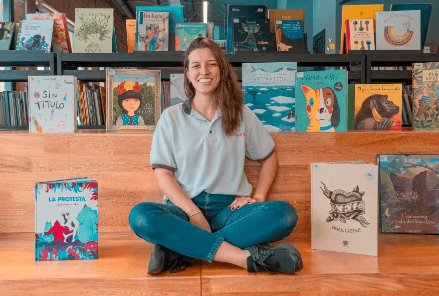 Cómo funciona Bono de lectura   Facilitadora Comfama rodeada de libros 