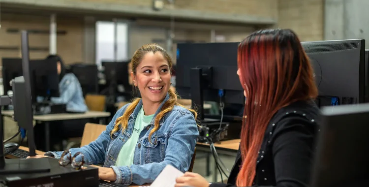 Mujeres utilizando un computador de escritorio.