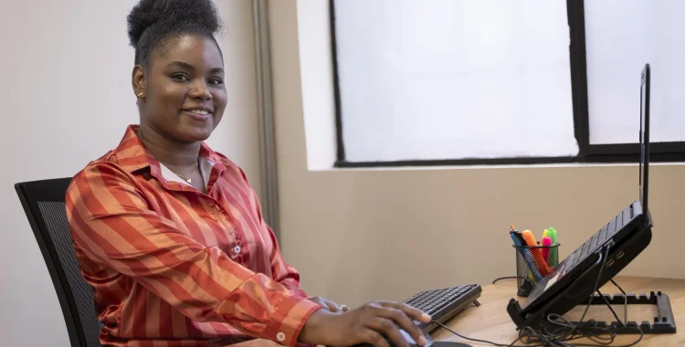 Mujer sonriendo en frente de un computador